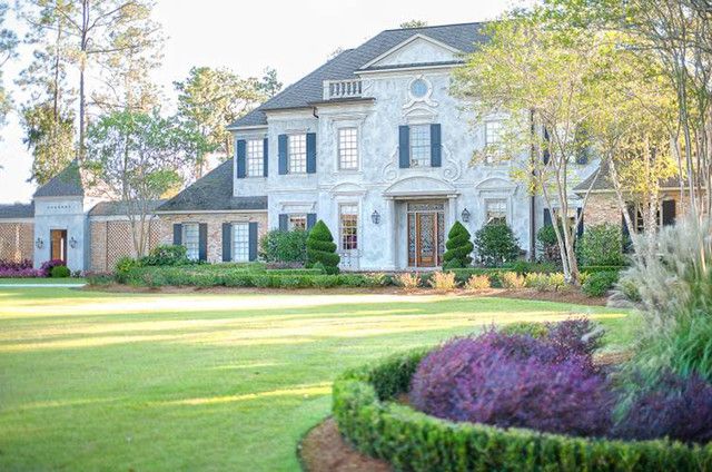 Luxury home with a manicured lawn, topiaries, and professional landscaping on the Northshore